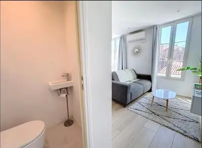 a bathroom with a toilet and a couch in a room at Cannes Croisette T2 new sublime in Cannes