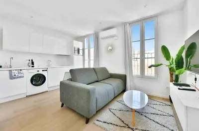 a living room with a couch and a kitchen at Cannes Croisette T2 new sublime in Cannes