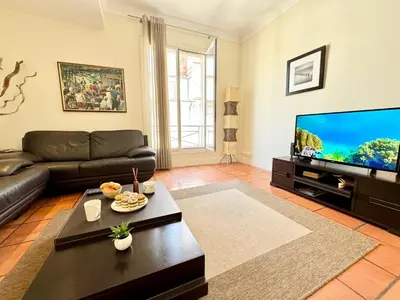 a living room with a couch and a flat screen tv at Grand Palais 4P BOB1309 in Cannes