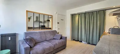 a living room with a couch and a large window at LX147 Studio lumineux centre, confort & autonomie in Cannes