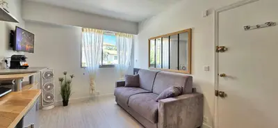 a living room with a couch and a kitchen at LX147 Studio lumineux centre, confort & autonomie in Cannes