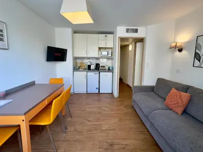 a living room with a couch and a table at Le Clémenceau - SCLS Locations in Cannes