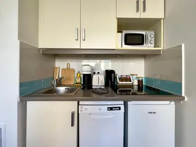 a kitchen with a sink and a microwave at Le Clémenceau - SCLS Locations in Cannes