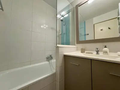 a bathroom with a sink and a tub and a mirror at Le Clémenceau - SCLS Locations in Cannes