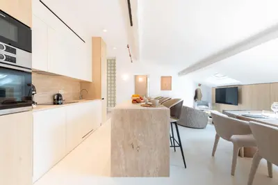 a kitchen and dining room with white cabinets and a table at 3-Br Attic Duplex Heart of Cannes in Cannes