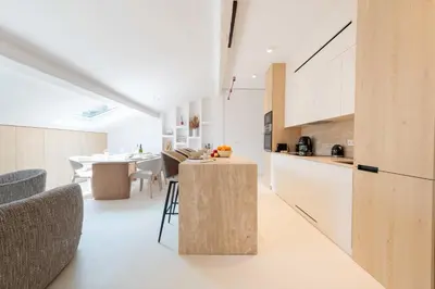 a kitchen and dining room with white cabinets and a table at 3-Br Attic Duplex Heart of Cannes in Cannes