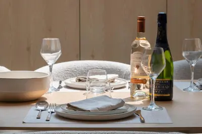 a table with a bottle of wine and glasses on it at 3-Br Attic Duplex Heart of Cannes in Cannes