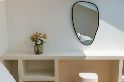a mirror on a white table with a vase of flowers at 3-Br Attic Duplex Heart of Cannes in Cannes