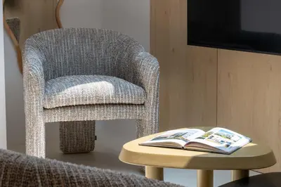 a chair and a table with a book on it at 3-Br Attic Duplex Heart of Cannes in Cannes