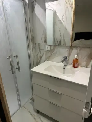 a white bathroom with a sink and a shower at Normandy in Cannes