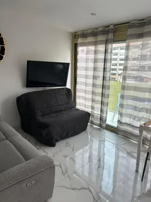 a living room with a couch and a flat screen tv at Normandy in Cannes