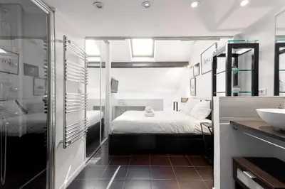 a bathroom with a bed and a sink in a room at Rue Lafontaine by Halldis in Cannes