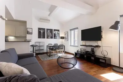 a living room with a couch and a tv at Rue Lafontaine by Halldis in Cannes