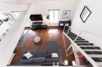 a living room with a couch and a staircase at Rue Lafontaine by Halldis in Cannes