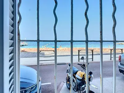 a motorcycle parked in a parking lot next to the beach at 126m2 - maison plage, 3 chambres, 3 salles de bain in Cannes