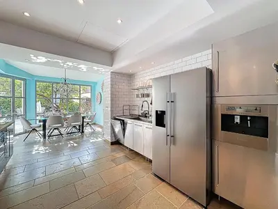a kitchen with stainless steel appliances and a dining room at 126m2 - maison plage, 3 chambres, 3 salles de bain in Cannes