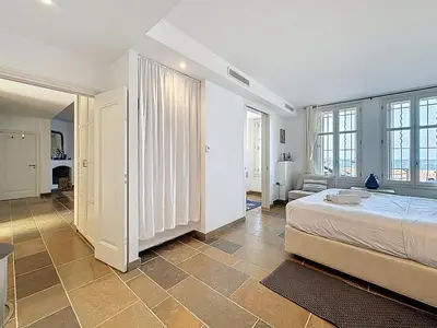 a bedroom with a large bed and a living room at 126m2 - maison plage, 3 chambres, 3 salles de bain in Cannes