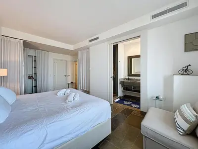 a white bedroom with a bed and a couch at 126m2 - maison plage, 3 chambres, 3 salles de bain in Cannes