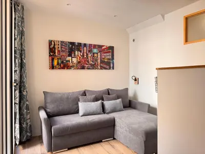 a living room with a couch and a painting on the wall at CB Cannes- NEW YORK in Cannes