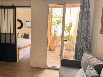 a living room with a couch and a sliding glass door at CB Cannes- NEW YORK in Cannes
