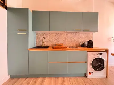 a kitchen with blue cabinets and a washing machine at CB Cannes - JUNGLE in Cannes