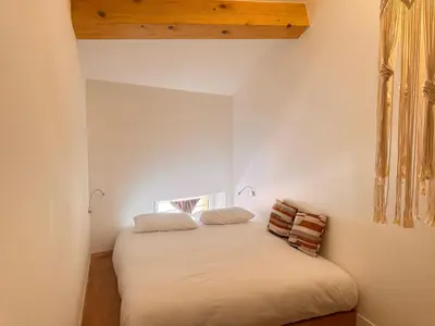 a bedroom with a white bed with two pillows at CB Cannes - JUNGLE in Cannes