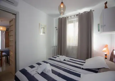 a bedroom with a bed with blue and white stripes at Le Jardin by Connexion in Cannes