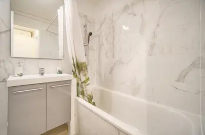 a white bathroom with a tub and a sink at Villa Francia 2P with splendid pool -private rental in Cannes