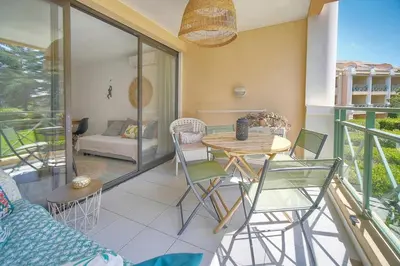 a room with a table and chairs on a balcony at Villa Francia 2P with splendid pool -private rental in Cannes