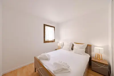 a bedroom with a bed with white sheets and a mirror at Cannes 2 bedrooms apartment - 141A in Cannes