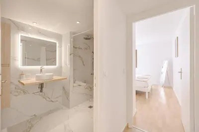 a white bathroom with a sink and a mirror at Cannes 2 bedrooms apartment - 141A in Cannes