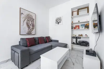 a living room with a couch and a tv at Appartement Beau Site - Welkeys in Cannes