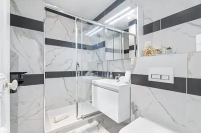 a bathroom with a shower and a toilet and a sink at Appartement Beau Site - Welkeys in Cannes