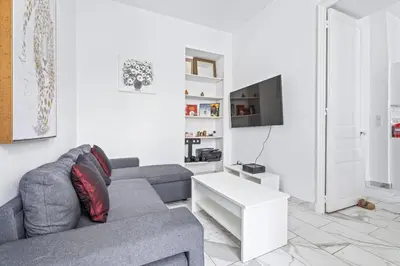 a living room with a couch and a tv at Appartement Beau Site - Welkeys in Cannes
