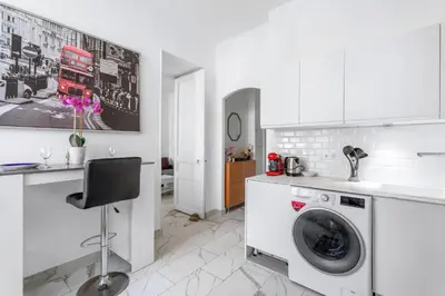 a white kitchen with a washing machine in it at Appartement Beau Site - Welkeys in Cannes