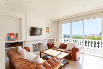 a living room with two couches and a fireplace at Grande villa proche plage vue îles, baie de Cannes in Cannes