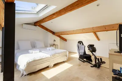 a bedroom with a bed and a desk and a chair at Grande villa proche plage vue îles, baie de Cannes in Cannes