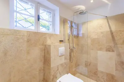 a bathroom with a shower with a toilet and a window at Grande villa proche plage vue îles, baie de Cannes in Cannes