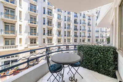 a table and chairs on a balcony with a building at L'ESPRIT CROISETTE avec balcon à cote du Martinez in Cannes