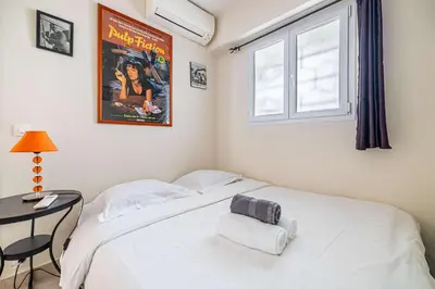a bedroom with a large white bed and a table at L'ESPRIT CROISETTE avec balcon à cote du Martinez in Cannes