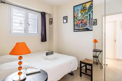 a bedroom with a bed and a table with a lamp at L'ESPRIT CROISETTE avec balcon à cote du Martinez in Cannes