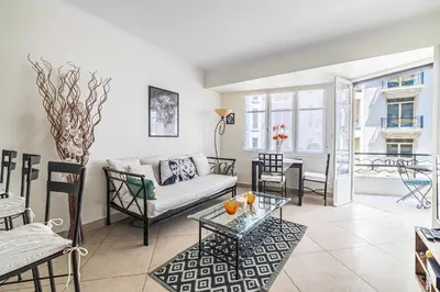 a living room with a couch and a table at L'ESPRIT CROISETTE avec balcon à cote du Martinez in Cannes