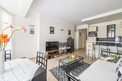 a living room with a table and a kitchen at L'ESPRIT CROISETTE avec balcon à cote du Martinez in Cannes