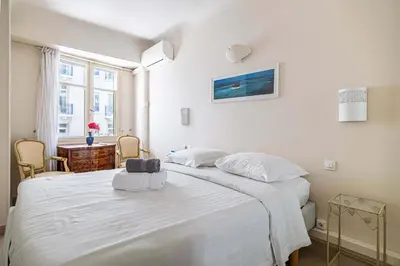 a bedroom with a large white bed and a desk at L'ESPRIT CROISETTE avec balcon à cote du Martinez in Cannes