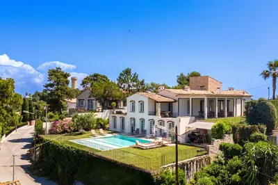 an exterior view of a house with a swimming pool at Villa exclusive au sommet de Cannes, 8 chambres, double piscine, vue sur la mer in Cannes