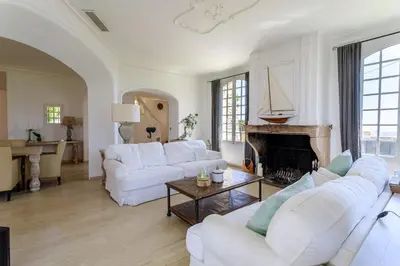 a living room with white furniture and a fireplace at Villa exclusive au sommet de Cannes, 8 chambres, double piscine, vue sur la mer in Cannes