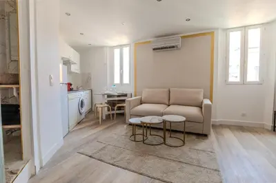 a living room with a couch and a kitchen at Renovated 1 bedroom - AC - City Center in Cannes