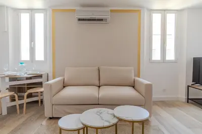 a living room with a couch and two tables at Renovated 1 bedroom - AC - City Center in Cannes