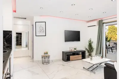 a living room with a tv on a white wall at Mimosas Lovers in Cannes