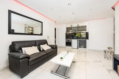 a living room with a black leather couch and a table at Mimosas Lovers in Cannes